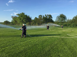 Übungseinsatz der Feuerwehr auf dem Sportplatz zur Unterstützung der Bewässerung nach Nematoden-Applikation.